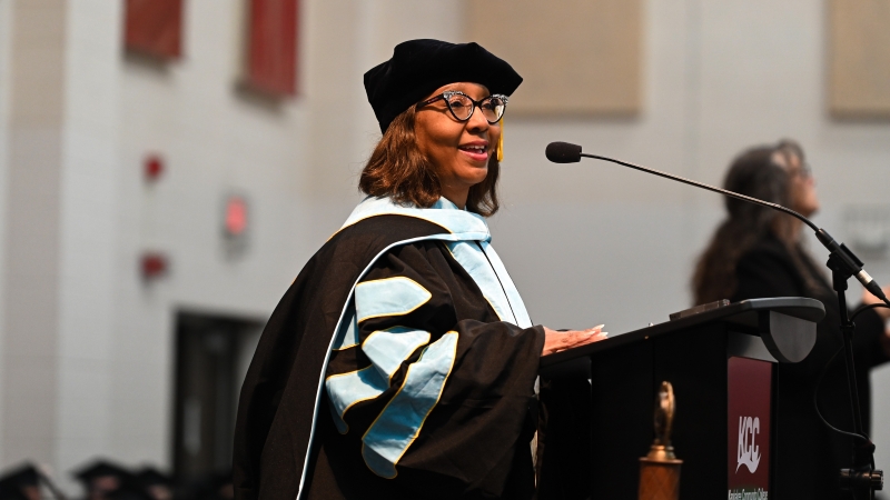 Vice President Quincy Sewell in black cap and gowns after commencement ceremony.