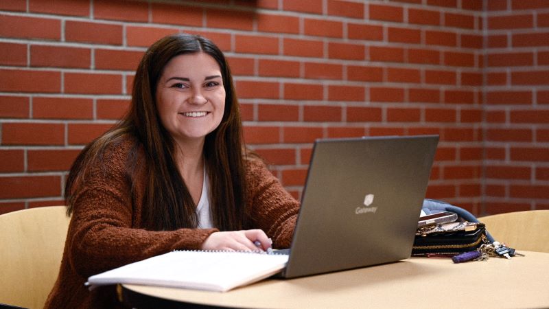 A student studying on her laptop next to Hammes Cafe.